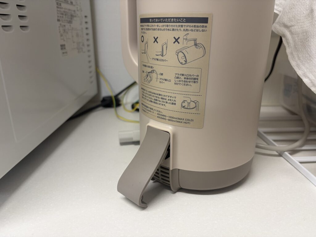 レコルト自動調理ポットのプラグ挿入口カバーを開き、差込口を確認している様子